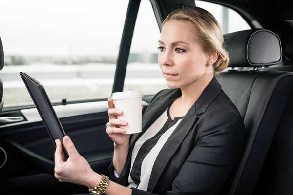 Femme d'affaires regardant tablette numérique dans la voiture — Photo