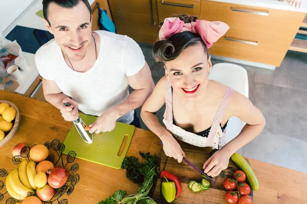 Mulher e homem cortando legumes para salada — Fotografia de Stock