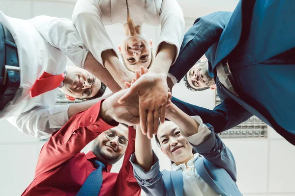 Team van diverse zakenmensen die hun handen samen stapelen — Stockfoto