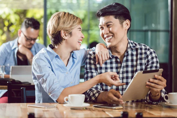 Casal olhando para tablet digital rindo — Fotografia de Stock