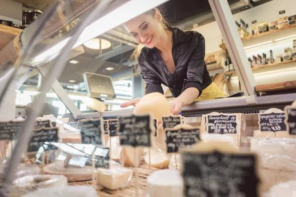 Shop írnok nő a szupermarket kijelző sajt válogatás — Stock Fotó