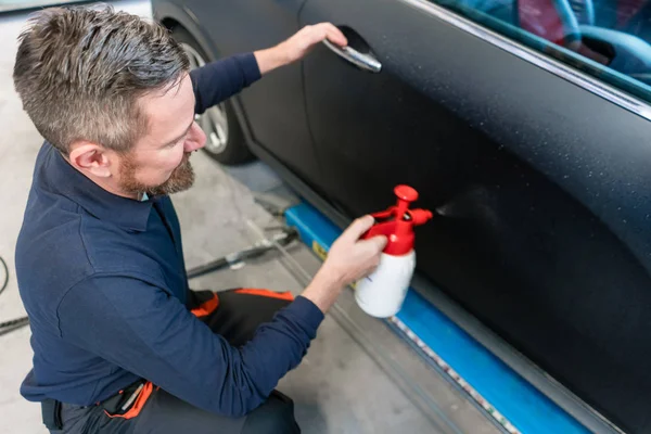 Man preparing car for putting advertisement sticker on it — Stock Photo, Image