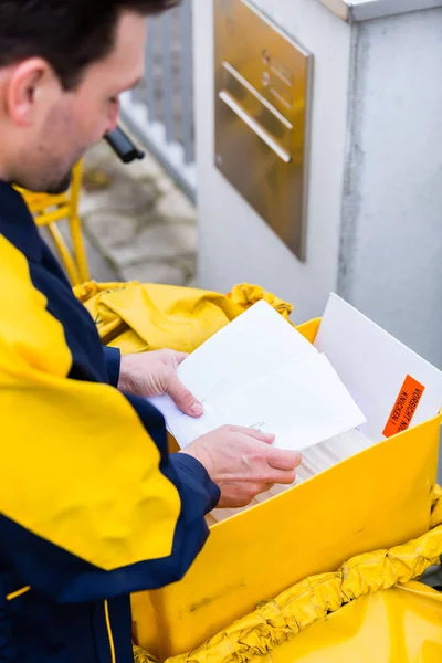 Postman доставляє листи до поштової скриньки отримувача — стокове фото