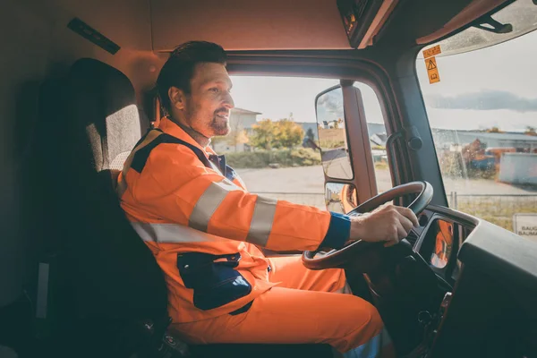 Garbage removal worker driving a dump truck — Stock Photo, Image