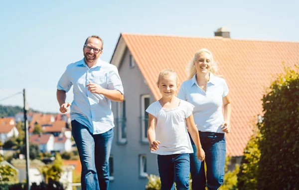 Mutlu aile yeni evlerinin önünde koşuyor