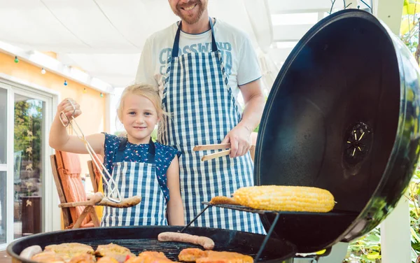 Dad and kid doing the barbeque at the grill — Stock Photo, Image