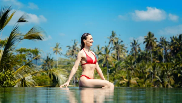 Donna in vacanza tropicale seduta nell'acqua della piscina — Foto Stock