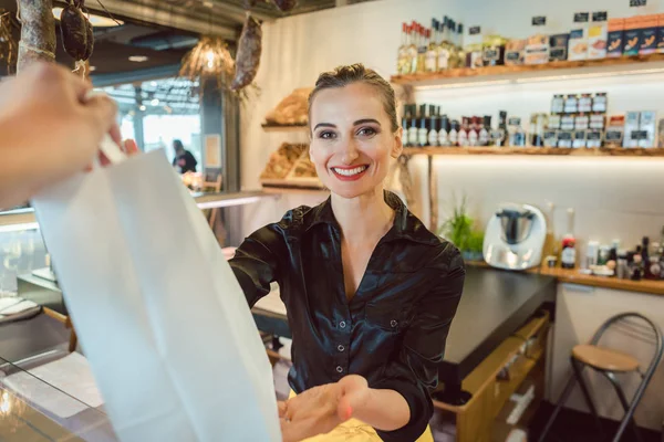 Shop Assistant overhandigen tas met boodschappen aan de klant — Stockfoto