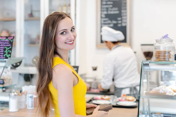 Vrouw in de banketbakker kiest zoete desserts — Stockfoto