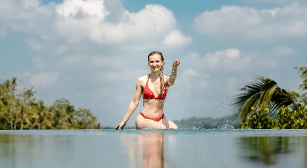 Nő játszik vízzel a medencében — Stock Fotó