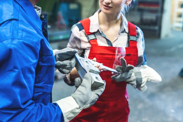 Mulher e homem trabalhador verificando medidas de peça de trabalho de metal — Fotografia de Stock