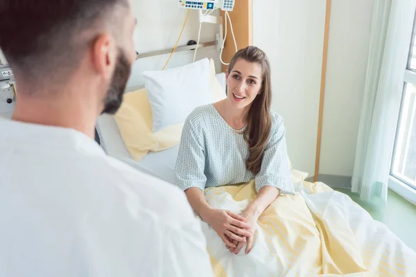 Patientin wartet im Krankenhausbett auf ihren Arzt — Stockfoto