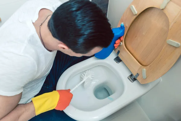 Man is a bit disgusted cleaning the toilet — Stock Photo, Image