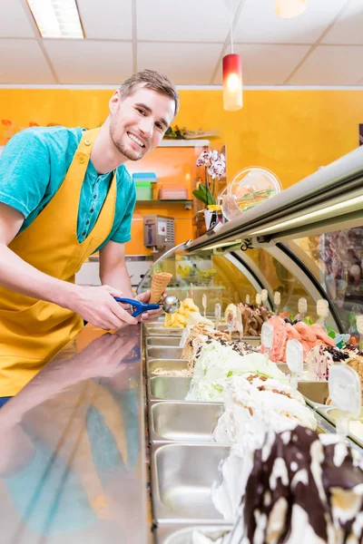 Ice cream seller in his shop at the counter — Stock Photo, Image