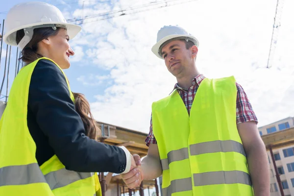 Архитектор и инженер или супервайзер пожимают руку на строительной площадке — стоковое фото