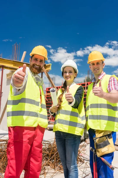 Drie collega's in een bouwteam die duimen omhoog laten zien tijdens het werk — Stockfoto