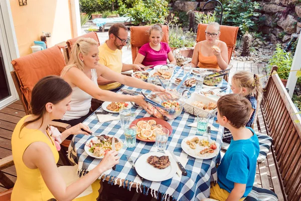Family having a garden party eating at the table — Stock Photo, Image