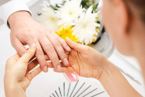 Pedicurist looking at fingernails of man prior to manicure — Stock Photo, Image
