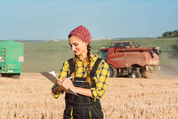 Agricultor no campo de trigo fazendo contabilidade sobre a colheita em curso — Fotografia de Stock