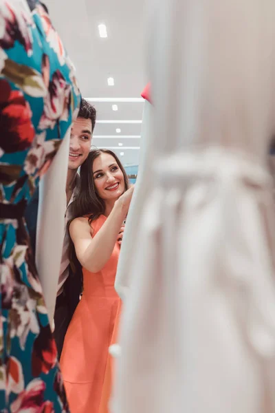 Mulher e homem olhando para vestidos em um manequim na loja de moda — Fotografia de Stock