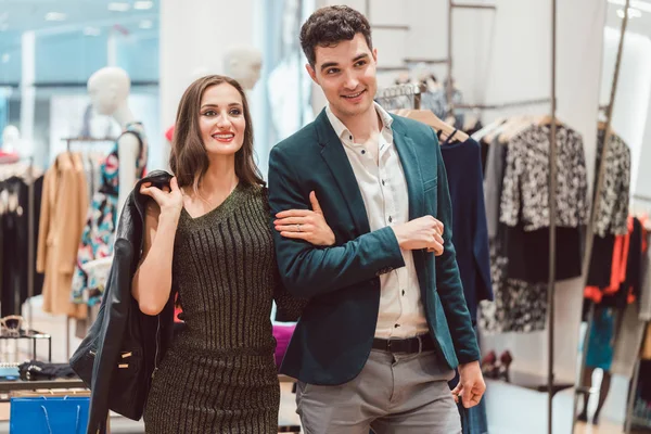 Mulher e homem de compras de roupas na loja de moda — Fotografia de Stock