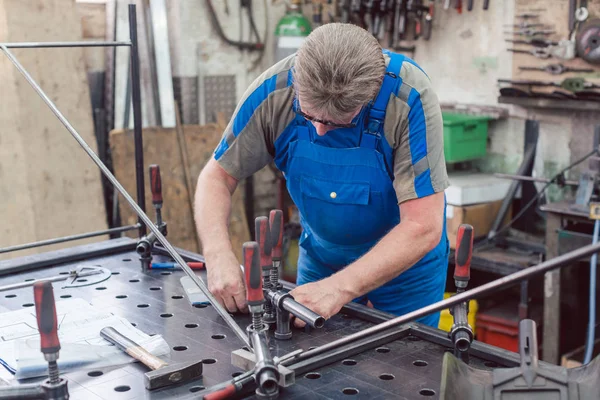 Lavoratore in officina metallurgica con utensili e pezzo da lavorare — Foto Stock