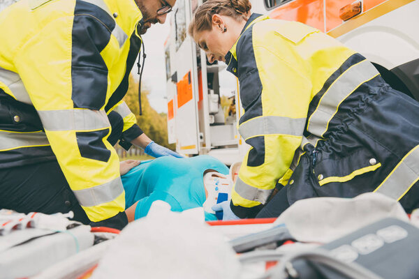 Paramedics performing first aid at ambulance