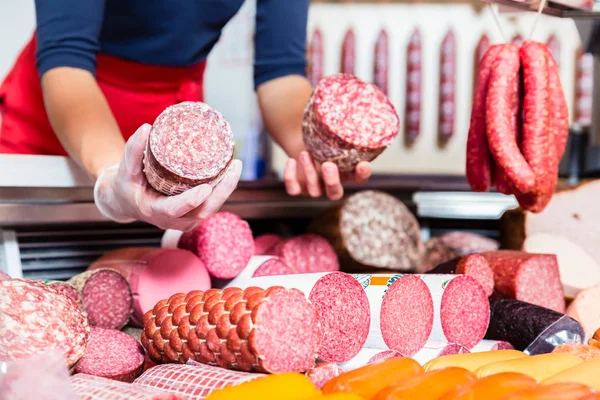 Butcher shop woman holding meat in her hand — Stock Photo, Image