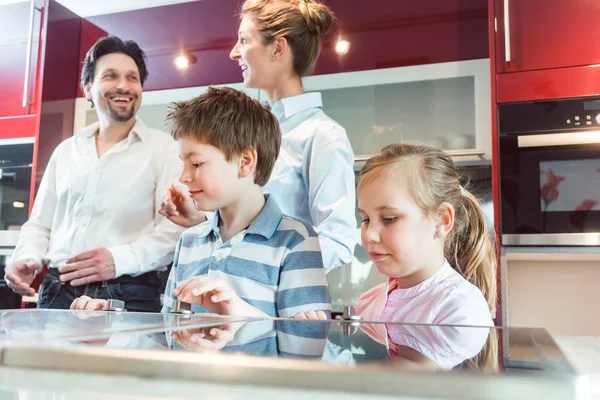 Παιδιά να ελέγξει έξω τη νέα κουζίνα τους γονείς τους που πρόκειται να αγοράσουν — Φωτογραφία Αρχείου