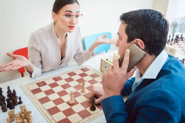 Uomini d'affari che giocano a scacchi con l'uomo al telefono — Foto Stock