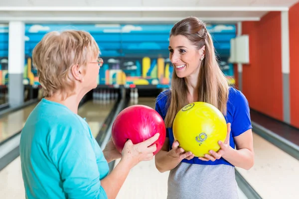 Madre e hija sosteniendo bola de bolos — Foto de Stock