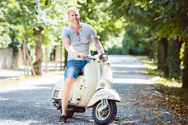 Young man riding old scooter — Stock Photo, Image