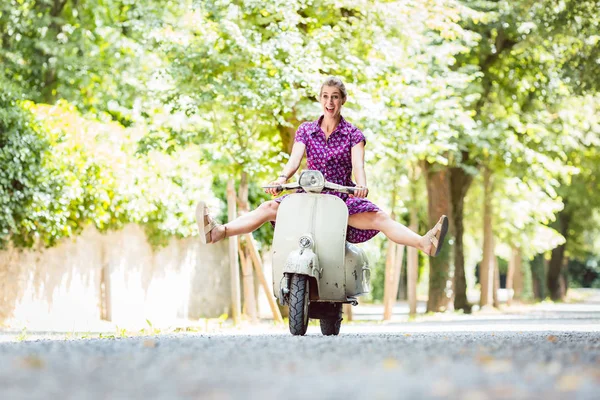 Mujer joven y despreocupada conduciendo scooter — Foto de Stock