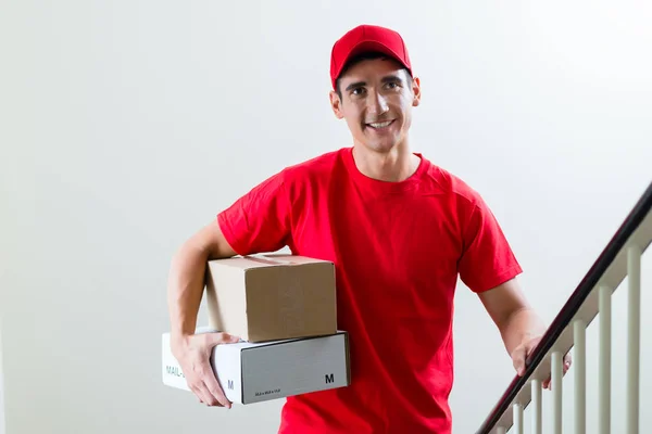 Homem de entrega alegre com caixas de correio de parcela — Fotografia de Stock