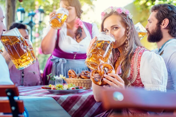 Γυναίκα στο Tracht κοιτάζοντας στην κάμερα, ενώ πίνοντας μια μάζα της μπύρας — Φωτογραφία Αρχείου