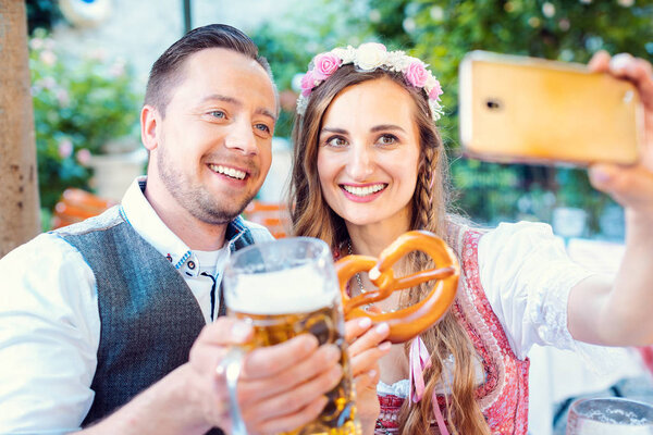 Couple in German beer garden taking a selfie picture with the phone