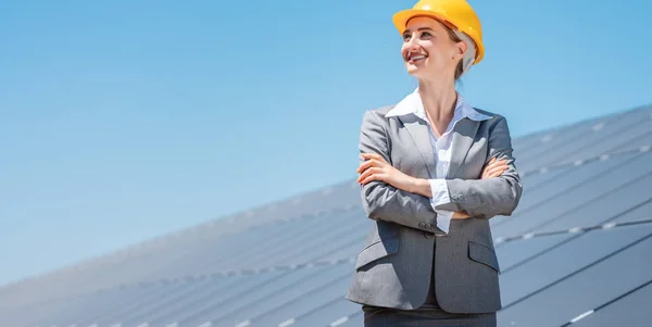 Mulher investidora em energia limpa em pé na frente de painéis solares — Fotografia de Stock