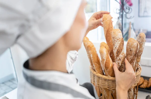 Wanita Baker menempatkan roti dalam keranjang untuk menjualnya — Stok Foto
