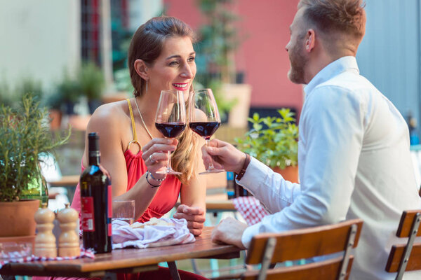 Young couple having red wine at restaurant