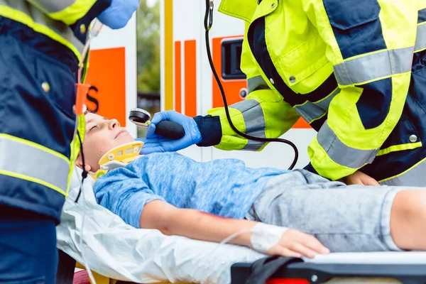 Ambulanspersonal mäta blodtryck av skadade pojken — Stockfoto