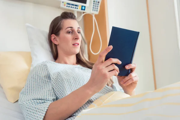 Γυναίκα στο κρεβάτι του νοσοκομείου διαβάζοντας τη Βίβλο — Φωτογραφία Αρχείου