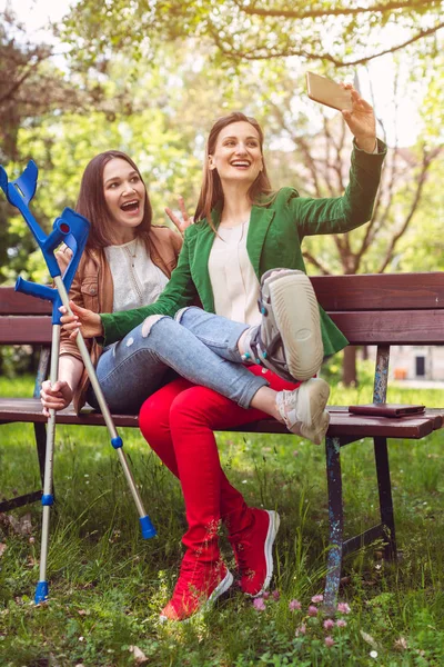 Sahabat baik dengan satu kaki patah mengambil selfie — Stok Foto