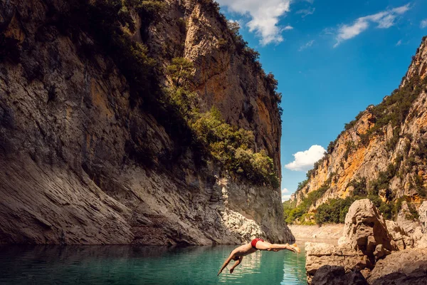 Homem pulando na água de um desfiladeiro nas montanhas dos Pirenéus — Fotografia de Stock