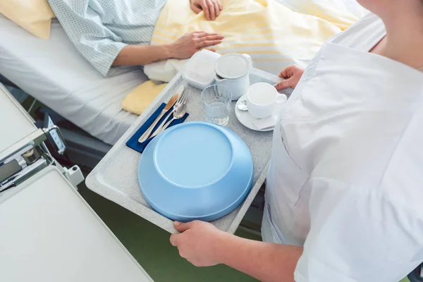 Krankenschwester serviert einem Patienten im Bett Essen im Krankenhaus — Stockfoto