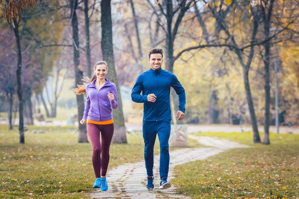 Mujer y hombre corriendo en el parque de otoño para el deporte — Foto de Stock