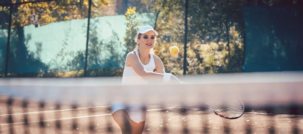 Γυναίκα παίρνει μια μπάλα στο γήπεδο του τένις — Φωτογραφία Αρχείου