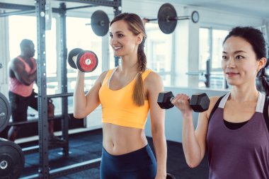 Spor salonunda birlikte fitness eğitimi yapan iki kadın