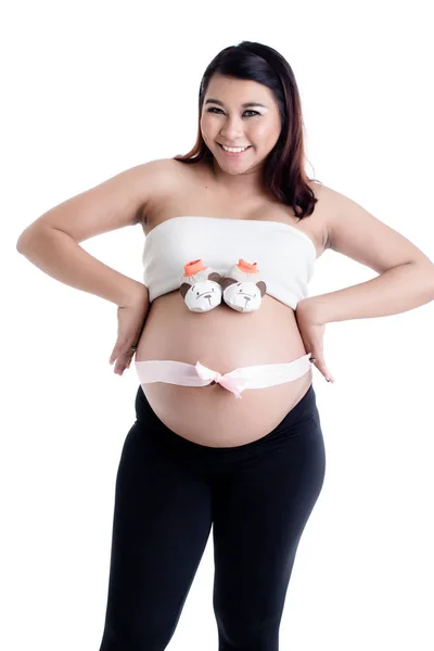 Mulher grávida barriga com sapatos de bebê e laço de fita — Fotografia de Stock