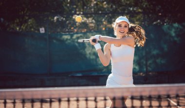 Kadın zorla tenis oynuyor.