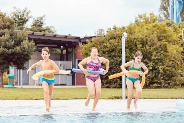 Amigos corriendo con tubo inflable —  Fotos de Stock